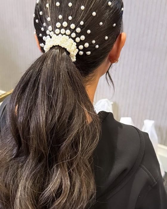 A sleek wedding ponytail with pearls set into the hair